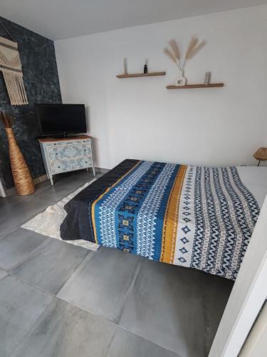 - une chambre avec un lit et une couverture colorée dans l'établissement Chambre d'hôtes privée et indépendante avec piscine, à Salon-de-Provence