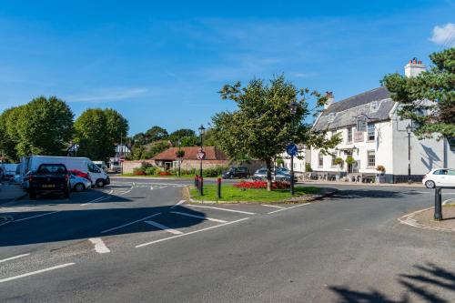 an empty street with cars parked in a parking lot at Bungalow Close to South Downs & Beach in Angmering
