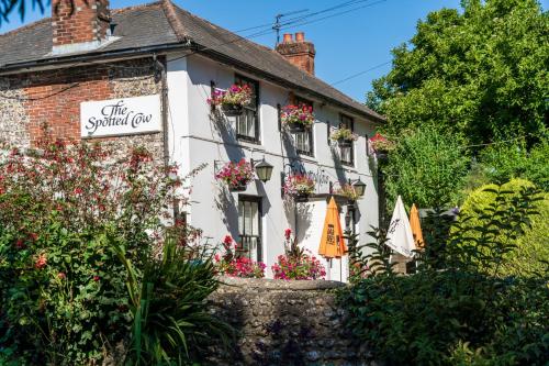 a white building with flowers on the windows at Bungalow Close to South Downs & Beach in Angmering