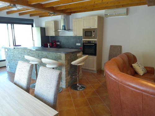 a kitchen with a bar with a couch and a table at Entre fleuve et centre ville in Cognac