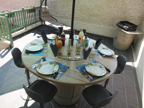 a table with chairs and plates and wine bottles on a patio at Entre fleuve et centre ville in Cognac