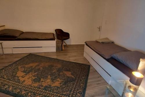 a bedroom with two beds and a rug at Stilvoll & Wohlfühlfaktor! in Nohfelden