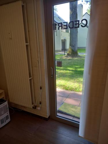 an open door leading to a door with a tree at Studio Ceder 1 in Houthalen-Helchteren