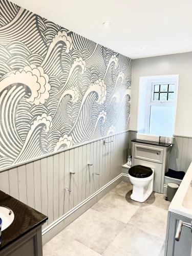 a bathroom with a wave mural on the wall at White Anchor Anglesey in Newborough