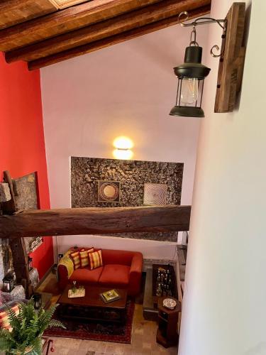 a living room with red walls and a red couch at Maison Divaga in Fleri
