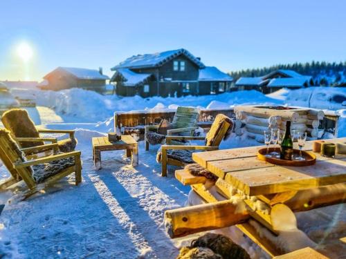 a wooden picnic table and chairs in the snow at Lyxig stuga på Branäsberget in Sysslebäck