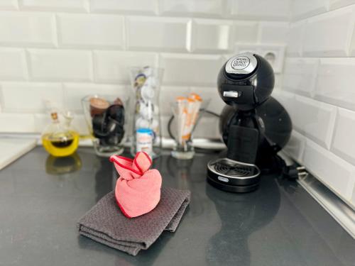 a pink felt heart sitting on a counter next to a coffee maker at Precioso piso Jávea in Jávea