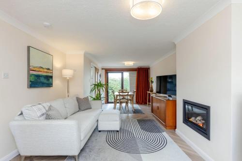 a living room with a white couch and a fireplace at 20 mins to Edinburgh 3 bedroom detached family house Wi-Fi Parking in Fife