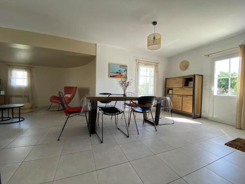 un salon avec une table et des chaises dans l'établissement Maison d'Évasion entre Plage et Forêt - Charme et Confort à Deux Pas de l'Océan, à Saint-Vincent-sur-Jard