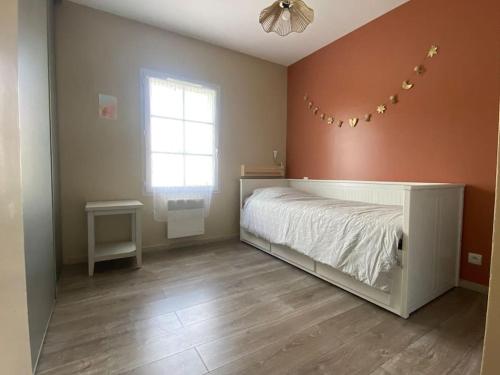 una camera da letto con un letto e una finestra di Maison d'Évasion entre Plage et Forêt - Charme et Confort à Deux Pas de l'Océan a Saint-Vincent-sur-Jard
