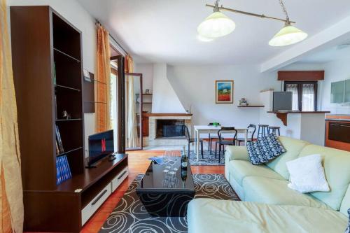 a living room with a couch and a dining room at Appartamento Confortevole, Wi-Fi & Colazione Free in Lanusei