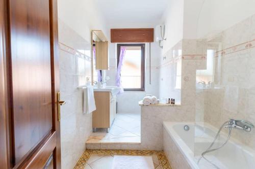 a bathroom with a tub and a sink at Appartamento Confortevole, Wi-Fi & Colazione Free in Lanusei