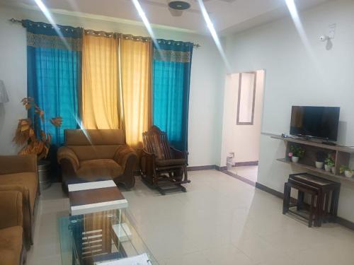 a living room with a couch and a tv at Capital Guest House, Islamabad near Bahria Town , Rawalpindi in Rawalpindi