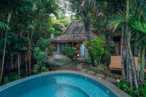 a swimming pool in front of a house with a resort at View Point Resort in Koh Tao