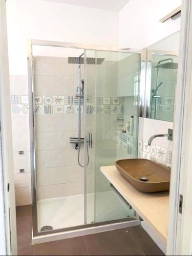 a bathroom with a glass shower with a wooden sink at Casa Giulù- in Palermo