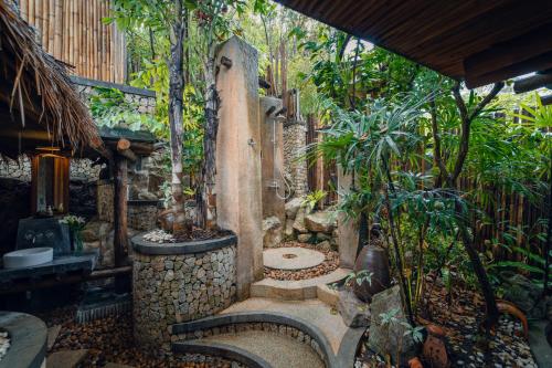 a bathroom with a stone shower in a garden at View Point Resort in Koh Tao