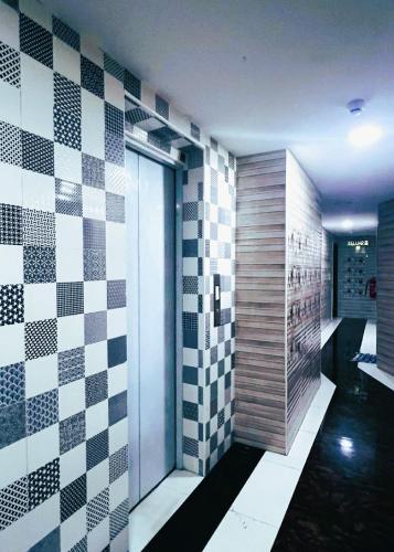 a bathroom with black and white checkered tiles on the wall at ARK HOTEL MELAWATI in Kuala Lumpur
