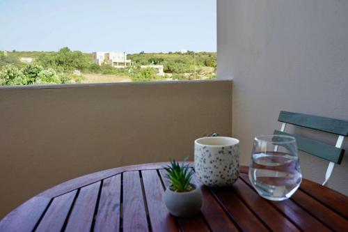 a wooden table with a glass of water and a vase at The Baker's Loft in Kýthira