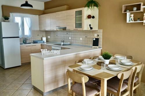 a kitchen with a table and a white refrigerator at The Baker's Loft in Kýthira