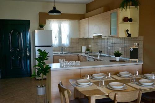 a kitchen with a table and a white refrigerator at The Baker's Loft in Kýthira