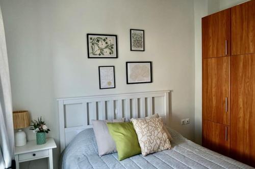 a bedroom with a bed with four pictures on the wall at The Baker's Loft in Kýthira