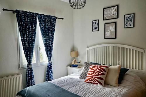 a bedroom with a bed with blue curtains and a window at The Baker's Loft in Kýthira