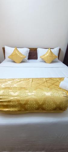 a bed with yellow sheets and pillows on it at Hotel VIP Prime in Puri