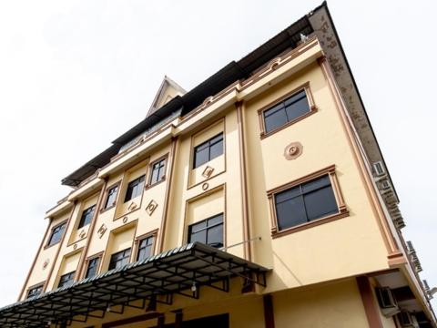 a tan building with a lot of windows at Pondok Wisata Istana XI in Medan
