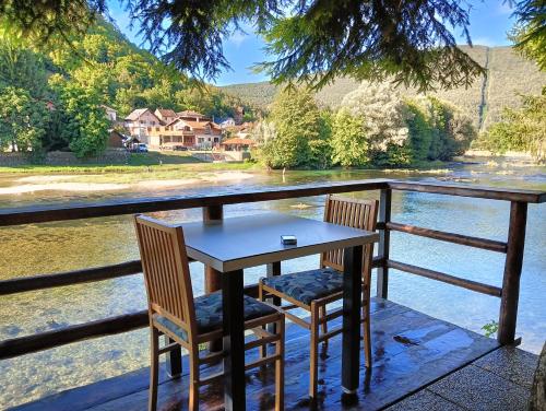 a table and two chairs sitting on a porch overlooking a river at Villa Medo in Kulen Vakuf
