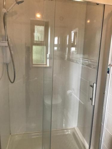 a shower with a glass door in a bathroom at Kesh Lakeside Cottage in Kesh