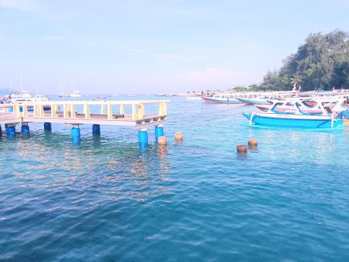 a dock in the water with boats in the water at Sea Breeze Villas - Gili Air, Lombok in Gili Air