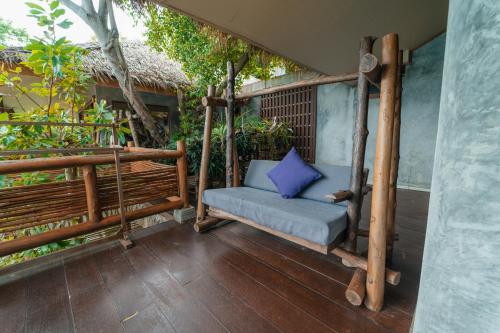 a porch swing with a blue pillow on it at View Point Resort in Koh Tao