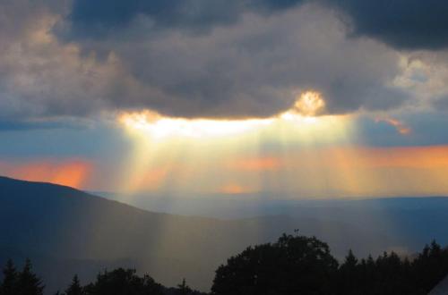 a rainbow in the sky with the sun poking through the clouds at Naturfreundehaus Brend in Neuweg