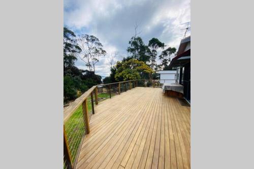 a wooden boardwalk leading up to a house at Fully fenced, wrap around decks, water on 3 sides in Lunawanna