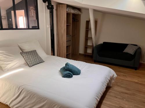 - une chambre avec un lit blanc et un canapé noir dans l'établissement Le Gambetta - spacieux et calme - climatisé, à Montauban