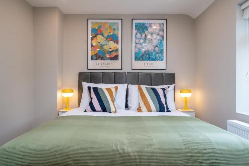 a bedroom with a large green bed with two lamps at Edgeware Home 4 Bedroom House-Free Parking in Edgware