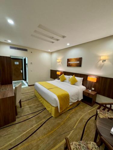 a hotel room with a large bed with yellow sheets at VERTA Almahbas Hotel in Makkah