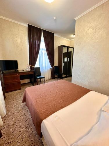 a hotel room with a bed and a desk and a computer at VLG Hotel in Boryspilʼ