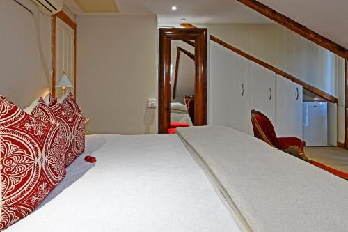 a bedroom with a bed with a red and white bedspread at Centre-Ville Guest House in Franschhoek