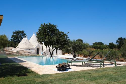 a swimming pool in front of a house at Borgo dei trulli Fanelli in Castellana Grotte