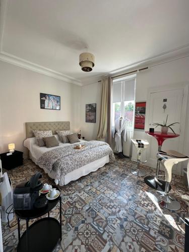 een slaapkamer met een bed, een tafel en stoelen bij KVS Concept Hébergement haut de gamme près du Circuit des 24 Heures du in Écommoy