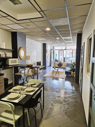 un salon et une salle à manger avec des tables et des chaises. dans l'établissement Sam ' Évasion, à Avion