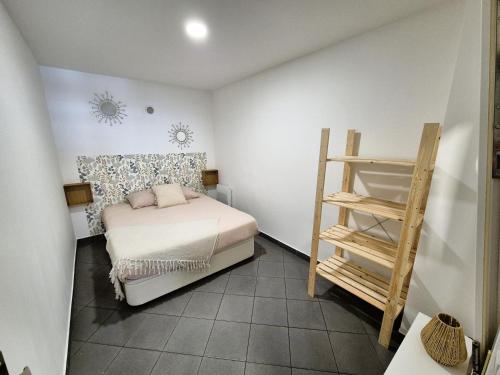 - une petite chambre avec un lit et une échelle en bois dans l'établissement Sam ' Évasion, à Avion