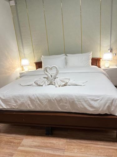 a bed with a heart decoration on top of it at Service Apartment Lampang Room101 ใจกลางเมืองใกล้กาดกองต้า in Lampang