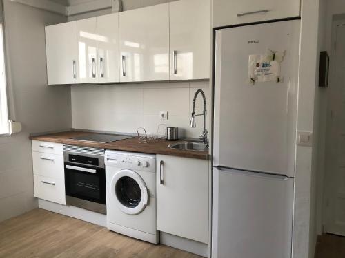 a kitchen with a white refrigerator and a dishwasher at Apartamento Playa de Tarifa in Tarifa