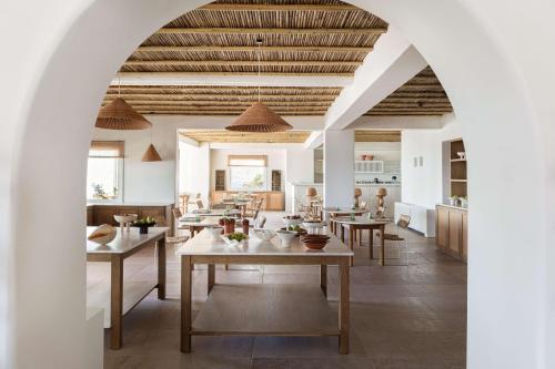 a dining room with tables and a kitchen at Porto Mykonos in Mýkonos City
