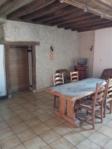 une salle à manger avec une table et des chaises en bois dans l'établissement La Forge, à Santilly