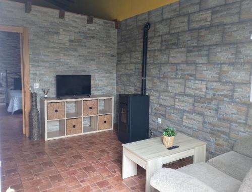 a living room with a tv and a couch and a table at La casona del Pantano in Los Campos