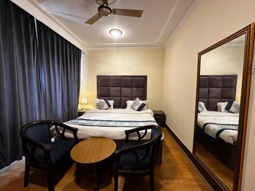 a bedroom with a bed and a mirror and a table at Srinagar Luxury Escape - Dilan Residency in Srinagar
