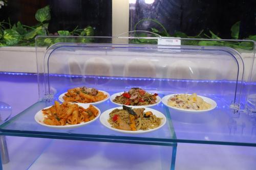 a glass display case with four plates of food at SkyCity Hotel Gurgaon in Gurgaon